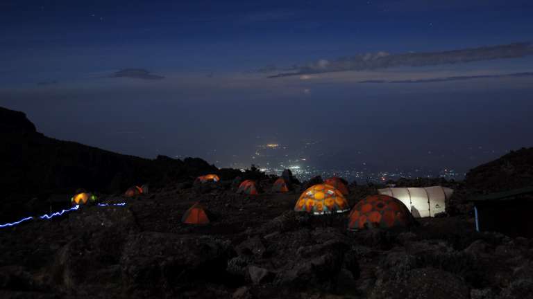 Lemosho Route base camp at night city lights below